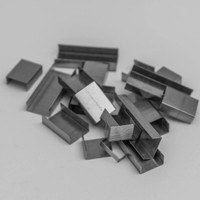 A monochrome photo of metal staples scattered on a grey surface, ideal for office concepts.